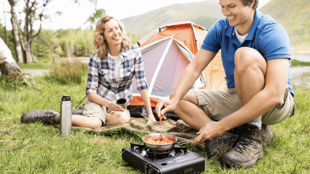 Man Prepares Meal On a Camping Stove