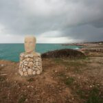 a head sculpture on pedestal of rocks in santa maria de leuca province of lecce italy