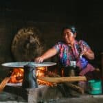 woman cooking by fireplace