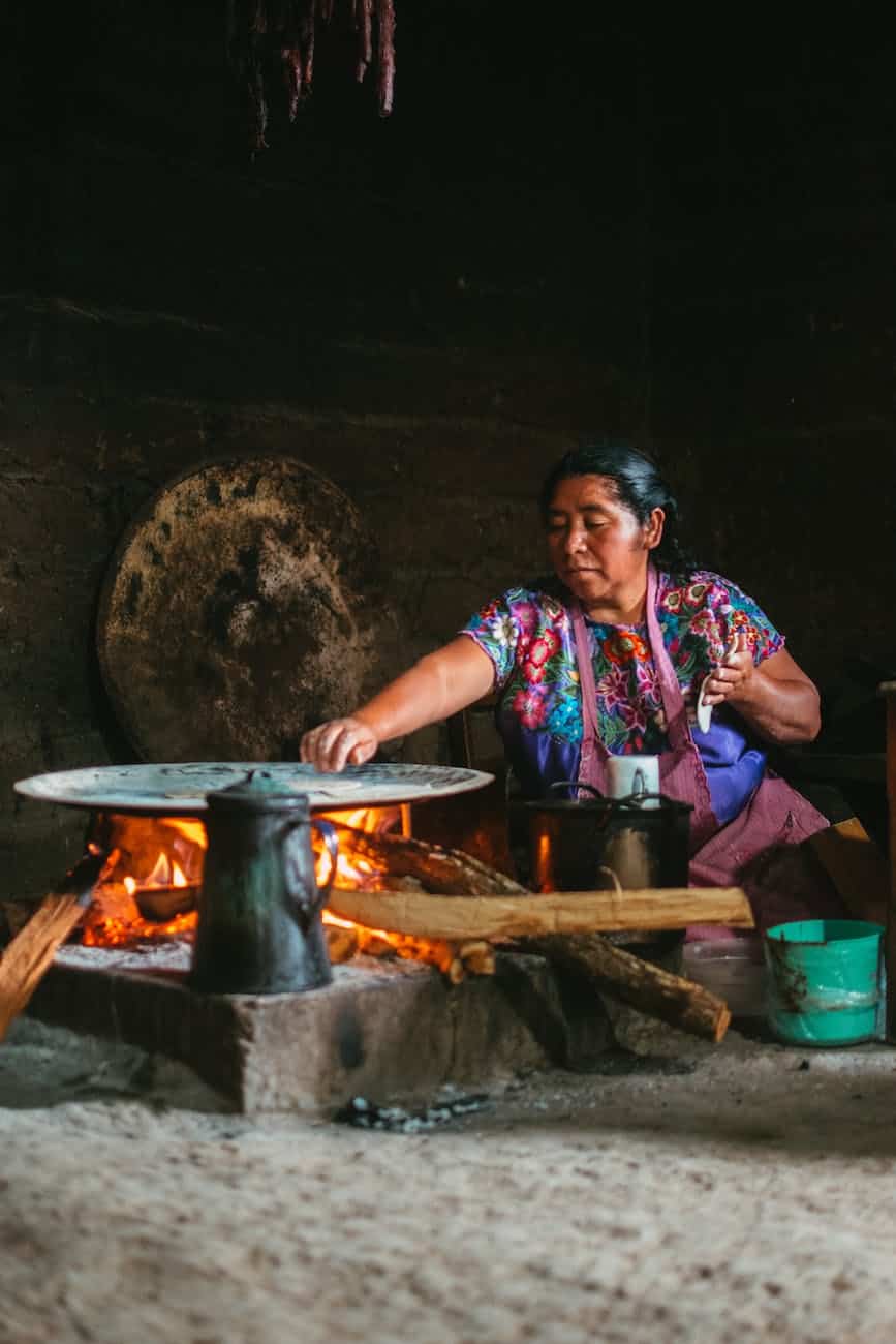 woman cooking by fireplace