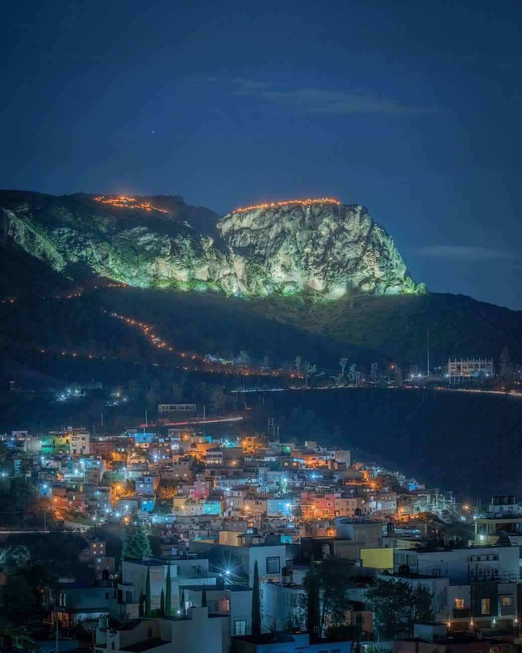city near mountain during night time
