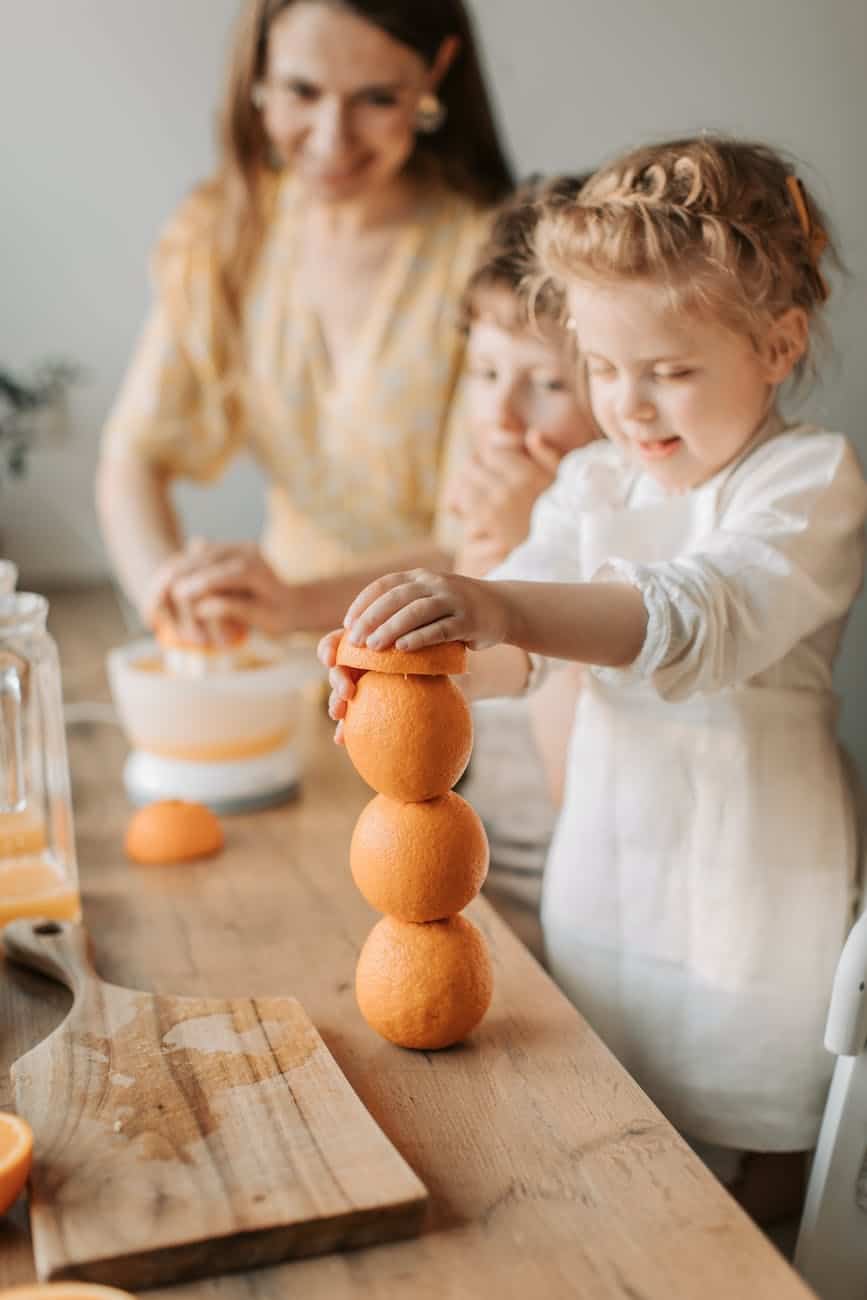 a girl stacking up some orange fruits