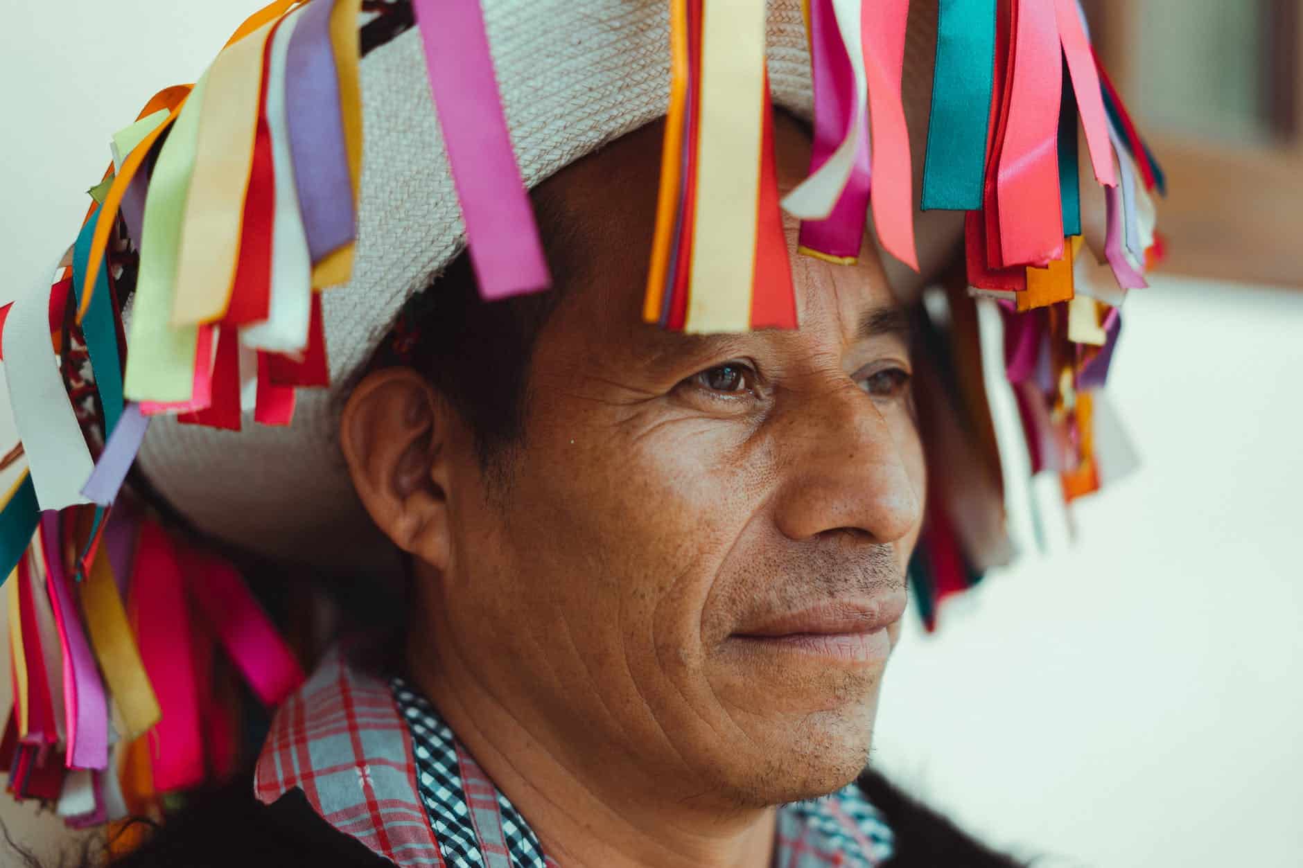 close up photo of man wearing traditional hat