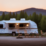 An image showcasing a picturesque campground at dusk, with an Aliner camper nestled among lush trees