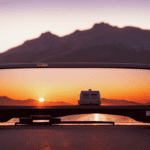 An image showcasing a striking sunset backdrop, casting a warm, golden hue over a sturdy truck camper